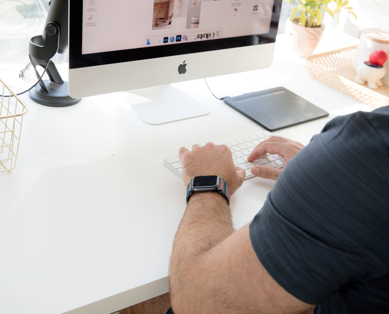 Personne qui travaille sur son ordinateur fixe à un bureau 
